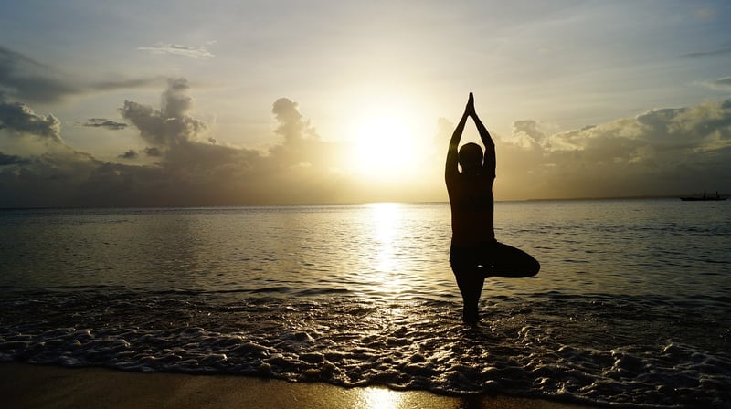 Woman practicing yoga by the sea